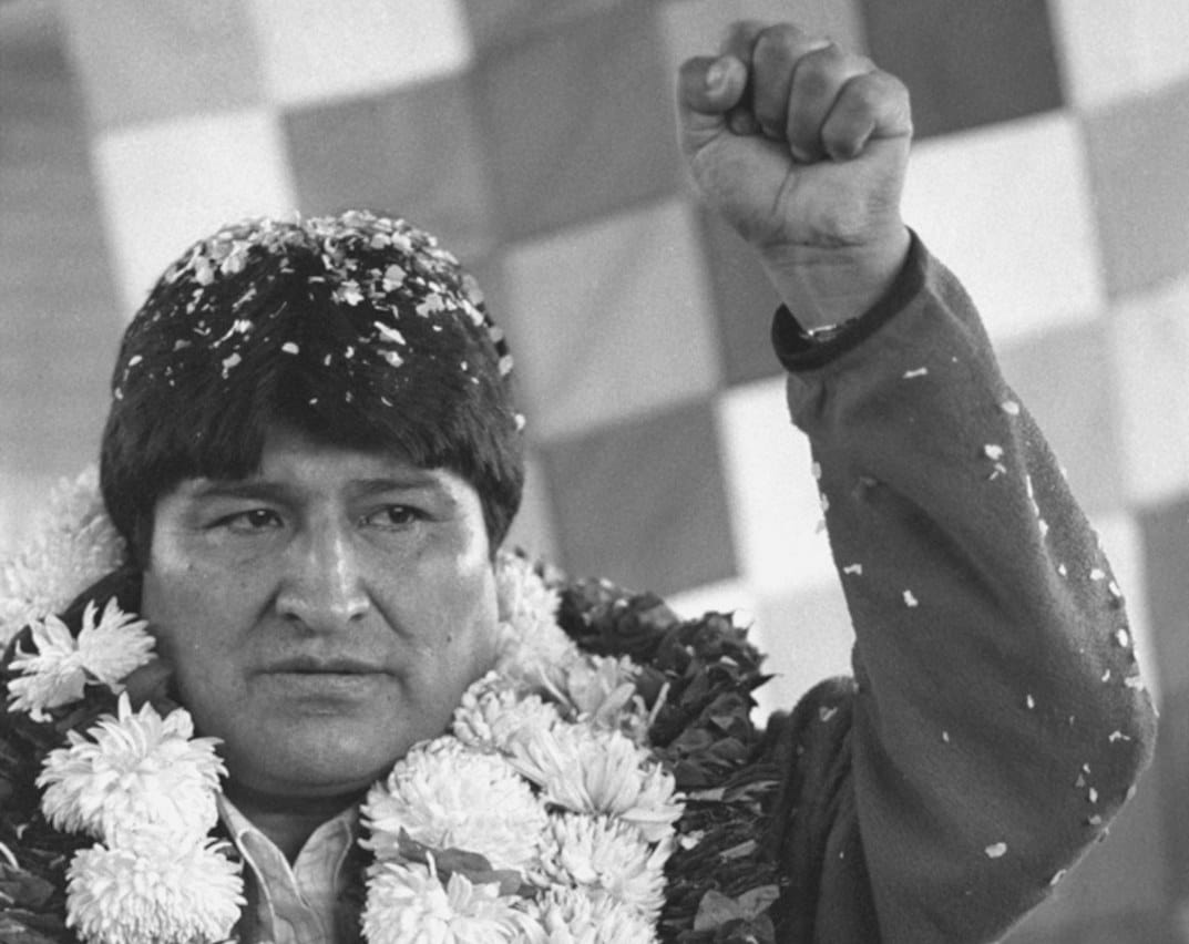 Bolivian president Evo Morales, wearing a necklace of flowers and coca leaves, lifts his left fist after being re-elected leader of the Six Federations of the Cochabamba Tropics, a post he has held since 1988, in Cochabamba, Bolivia, February 14 2006. Photographer: Jorge Uzon