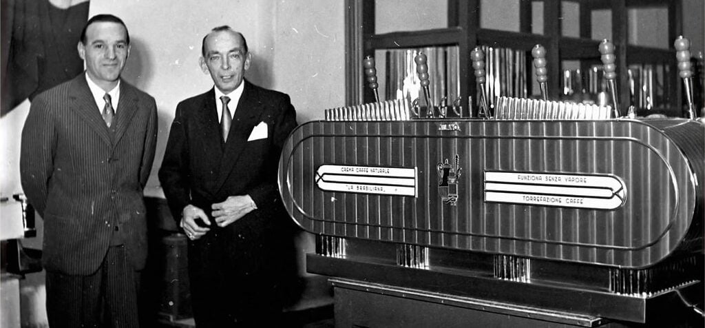 Achille Gaggia next to the first fully automatic espresso machine patented in 1938.